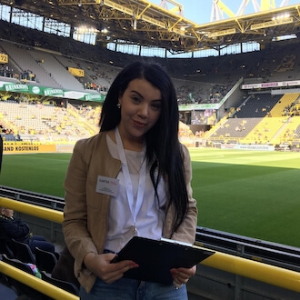Interviewerin im Fußballstadion mit Umfragebogen in der Hand
