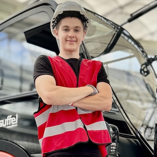 Eventhelfer mit roter Warnjacke und Helm