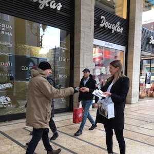 Eine Promoterin beim Verteilen von Duftproben auf der Straße